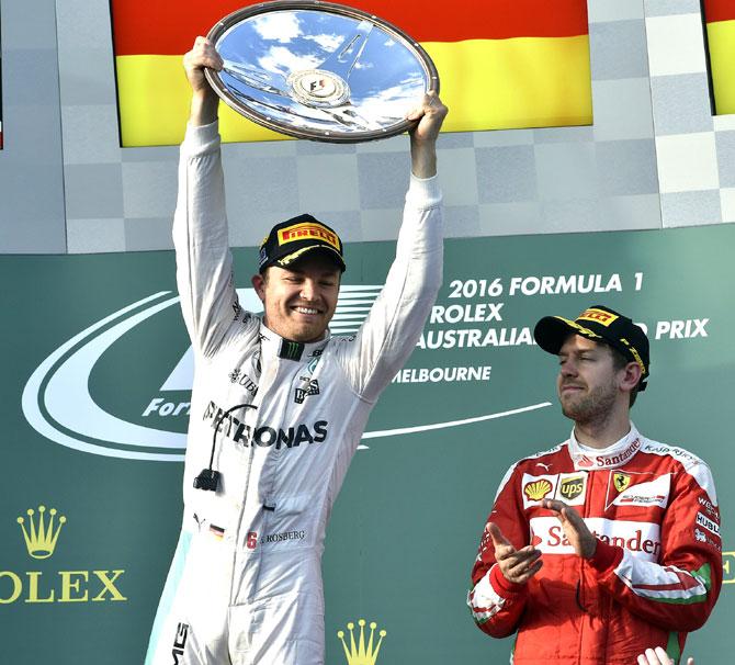 Mercedes AMG Petronas F1 Team-s German driver Nico Rosberg celebrates his victory as Ferrari-s German driver Sebastian Vettel C and former British driver Sir Jackie Stewart R applaud on the podium at the end of the Formula One Australian Grand Prix in Melbourne. Pic/AFP