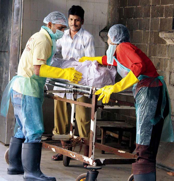 Helpers dispose of the body of a TB patient using their new gear. pics/ajinkya sawant