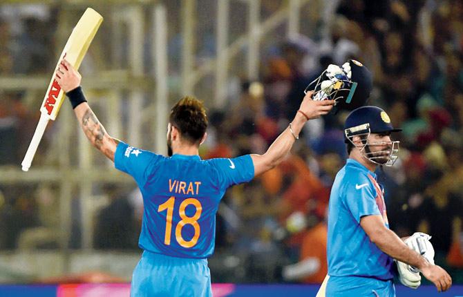 India’s Virat Kohli raises his bat as skipper MS Dhoni is all set to head to the pavilion after beating Australia in the ICC World T20 game at Mohali on Sunday. Pic/AFP