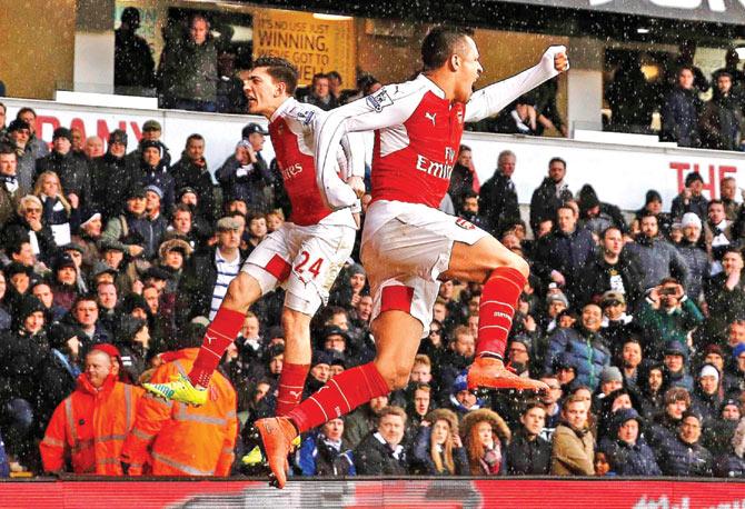 Arsenal striker Alexis Sanchez (right) celebrates with teammate Hector Bellerin after scoring their second goal during the English Premier League match against Tottenham Hotspur at White Hart Lane in London on Saturday
