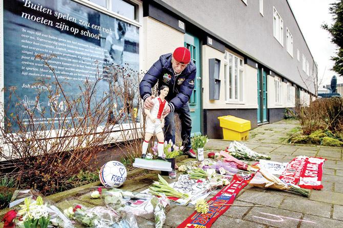 A fan places a statue among other floral tributes outside the family home of the late Johan Cruyff in Amsterdam yesterday. Pic/AFP