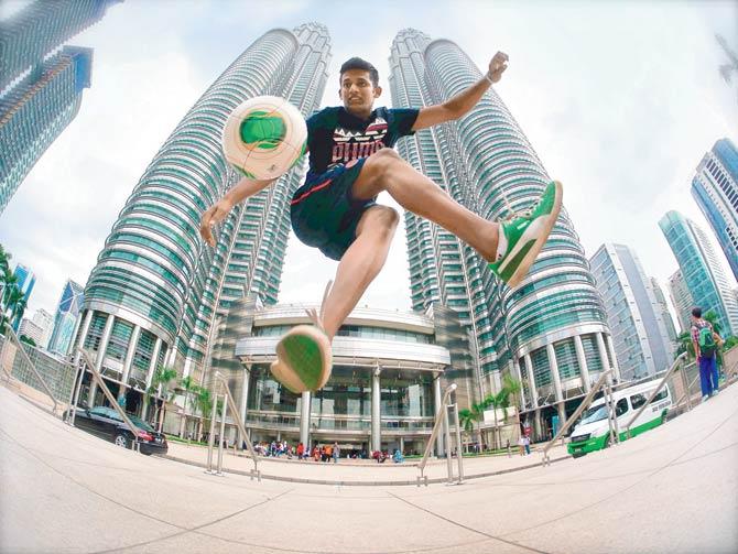 Archis Patil shows off his football freestyling skills in front of the Petronas Towers in Kuala Lumpur