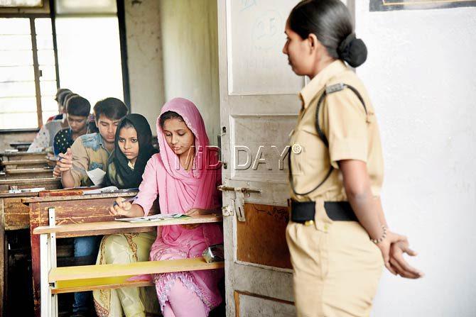 A female cop observes an exam hall at the NKT college in Thane. Pic/Sameer Markande
