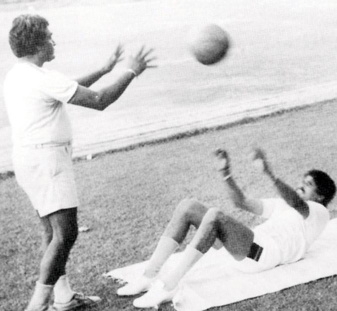 Coach DP Azad throws a ball to Kapil Dev in a training session