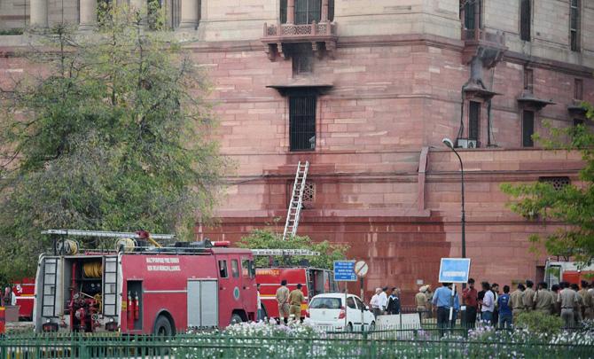 Firefighters douse a minor fire that broke at South Block Gate number 8 in New Delhi on Sunday. Pic/PTI