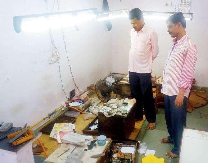 Employees of Kantibhai Vaya, whose workshop was also broken into, look at their work stations after the failed robbery