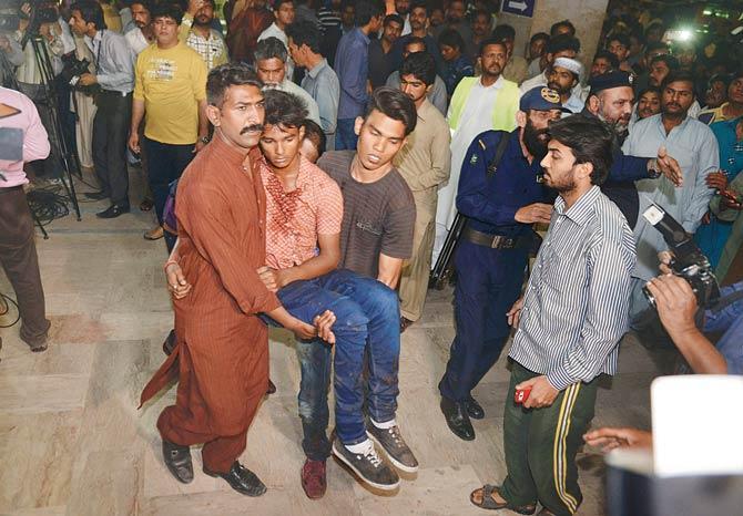 An injured bomb blast victim being taken to a hospital after the bomb blast in Lahore. Pic/AFP