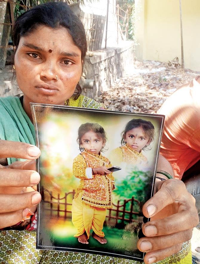The deceased four-year-old’s mother holds up his picture. His parents had found his body floating in the water-logged lift duct. Pic/Navneet Barhate