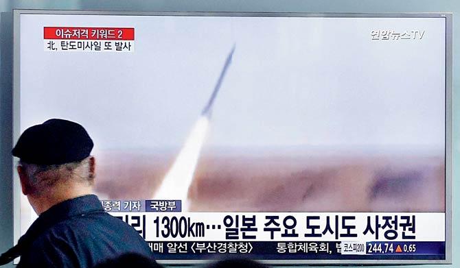 A man watches a TV screen showing file footage of the missile launch conducted by North Korea, at Seoul Railway Station in Seoul,  South Korea on Friday. The letters on the screen read “The missile [launched yesterday] puts all of South Korea and part of Japan within striking distance.” Pic/AFP