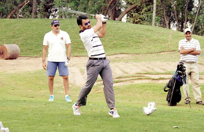 India captain MS Dhoni hits out on a golf course in Chandigarh watched by Team Director Ravi Shastri yesterday.  PIC/Suman Chattopadhyay 