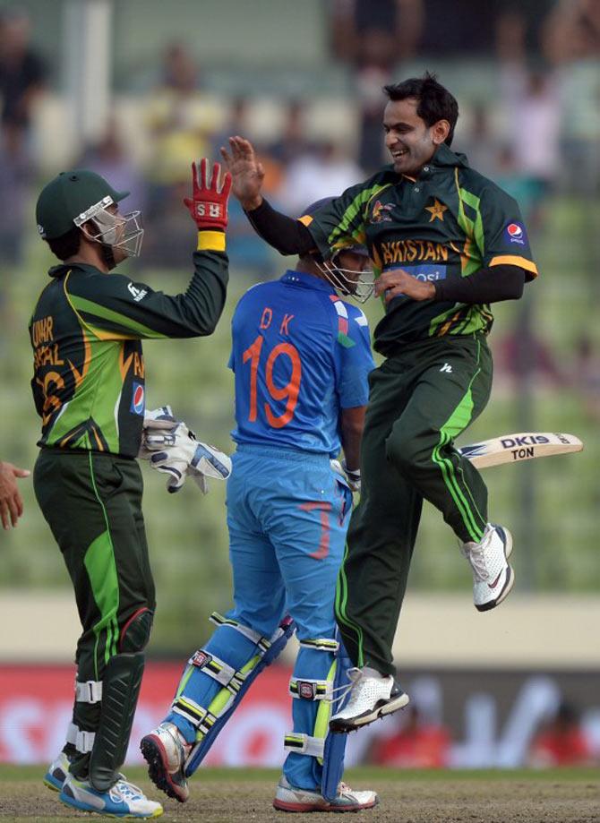 Mohammad Hafeez (R) celebrates the wicket of Indian batsman Dinesh Karthik with teammate Umar Akmal