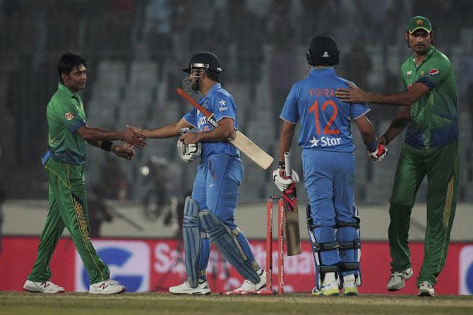India’s captain Mahendra Dhoni, center left, greets Pakistan