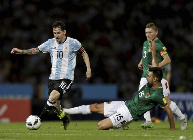  Lionel Messi, left, fights for the ball with Bolivia