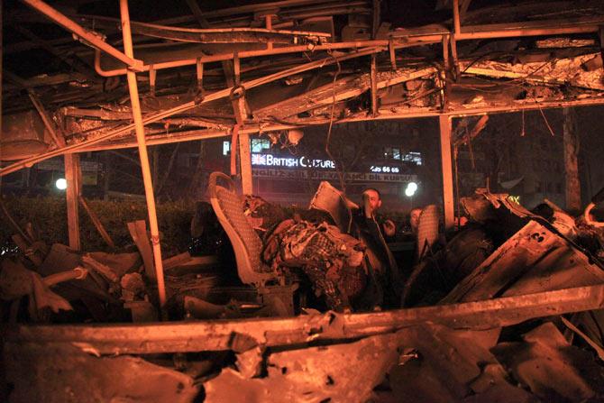 A man looks into a burnt-out bus at the site of a blast in Ankara on March 13, 2016. A suicide car bomb ripped through a busy square in central Ankara 