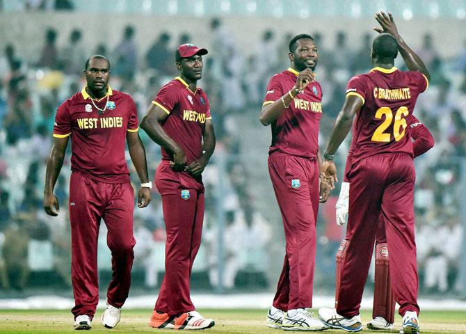 Captain Darren Sammy with other players celebrate after fall of an Indian wicket 