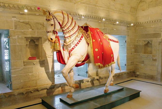 A traditional caparisoned horse in Amar Mahal, a marble ashlar masonry palace converted into the Silver Gallery, featuring silver artefacts used for pujas, about 450 vanity items, royal transport  like a buggy and elephant and horse jewellery