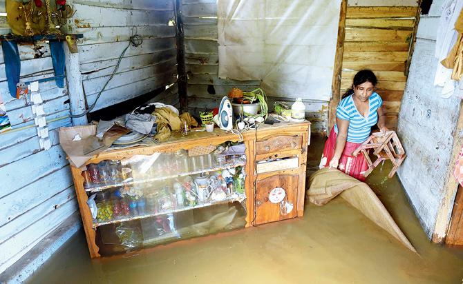 A Sri Lankan woman wades through floodwaters inside her home in Kelaniya yesterday. Pic/AFP