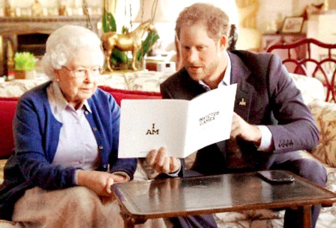 This image shows Queen Elizabeth II sitting with her grandson, Prince Harry looking at an Invictus Games brochure. Pics/AP