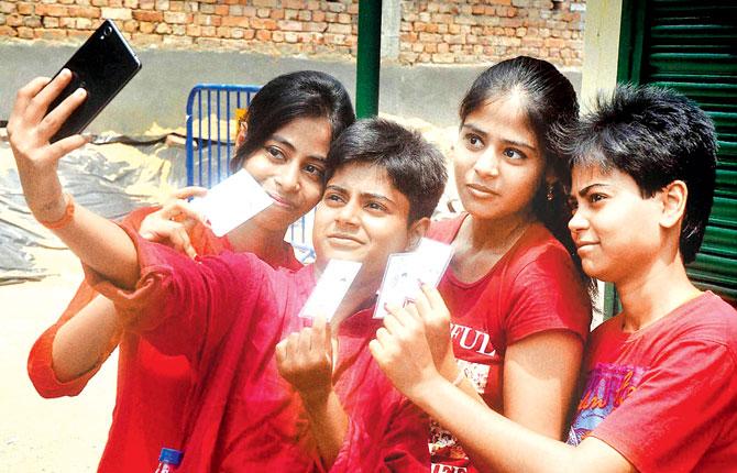 Young girls take a selfie after casting their votes at a polling station during the fifth phase of West Bengal Assembly elections in Kolkata on Saturday. Pic/PTI 