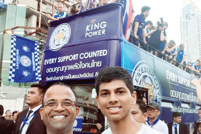 Sunny D’Souza and family friend Joel Frois pose in front of the EPL champion outfit’s open top bus ride in Bangkok, Thailand on Thursday 