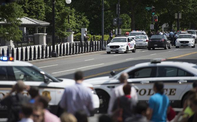 Secret Service vehicles and police are seen near the Eisenhower Executive Office Building after the White House was briefly placed on lockdown Friday