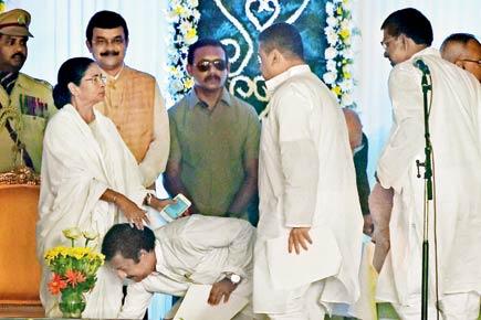 Didi takes oath as CM, ministers fall at her feet
