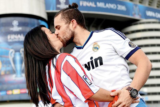 Rival kiss: Real Madrid and Atletico Madrid fans kiss each other
