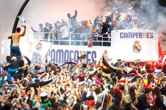 Jubilant Real Madrid fans welcome their team home as they parade the European Cup on an open-top bus tour in Madrid yesterday. Pic/AFP