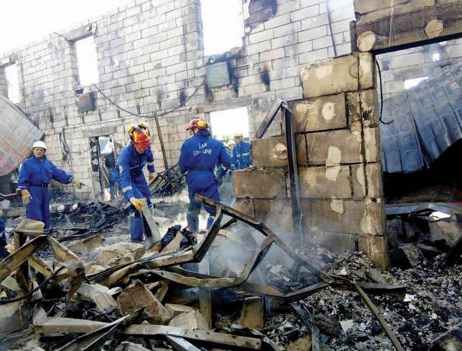 Emergency ministry employees search the site of fire. Pic/AP