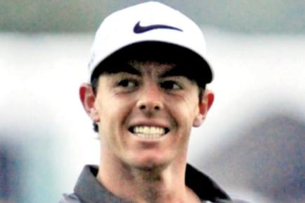 Golf ball with an earplug attached lands near Rory McIlroy