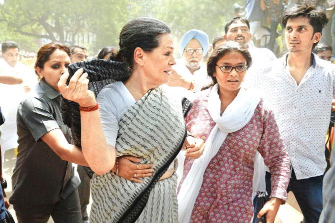 Gandhi being taken away by security personnel after party workers come too close to her. Pics/PTI