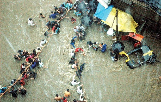 Humans of Bombay: People help each other as they make their way out of the flooded streets during the 26/7 deluge. File pic/Rane Ashish