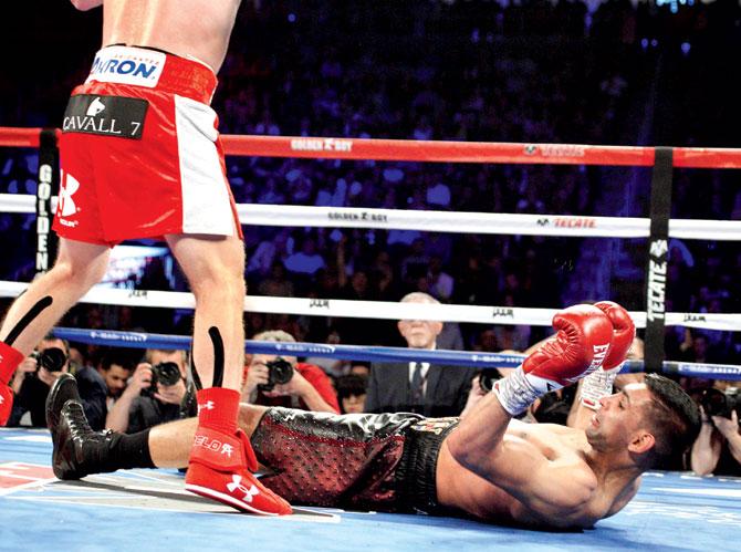 Amir Khan is knocked down during his WBC middleweight title fight against Saul 