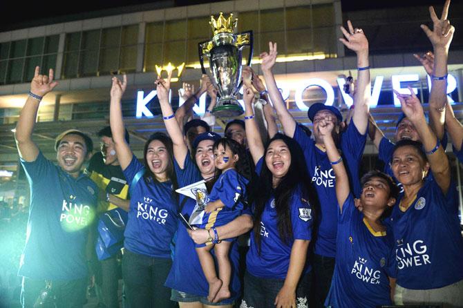 Leicester City FC fans pose with a replica Premier League trophy before a live screening of the Leicester vs Everton football match at King Power headquarters in Bangkok. Pic/AFP
