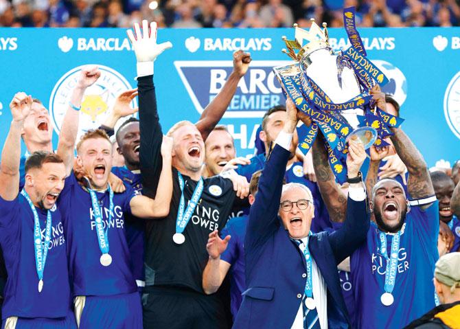 Leicester City players celebrate as captain Wes Morgan (right) and manager Claudio Ranieri (centre) lift the English Premier League trophy at King Power Stadium in Leicester on Saturday. Pics/AFP