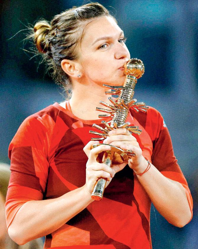 Red hot: Romanian Simona Halep kisses the Madrid Open trophy after beating Slovakian Dominika Cibulkova 6-2, 6-4 in the final in Madrid on Saturday night. Pic:AP/PTI