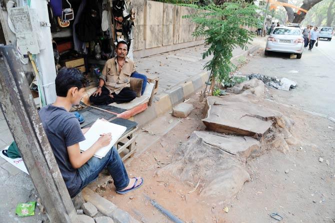 JJ School student Aman Negi sketches a tree stump near a cobbler’s stall on 14th Road, Khar. Pic/Justin Ponmany