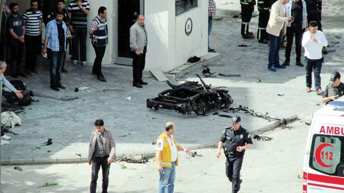 Security and forensic officials investigate around the remains of a car after an explosion outside a police station in Turkey. Pic/AFP