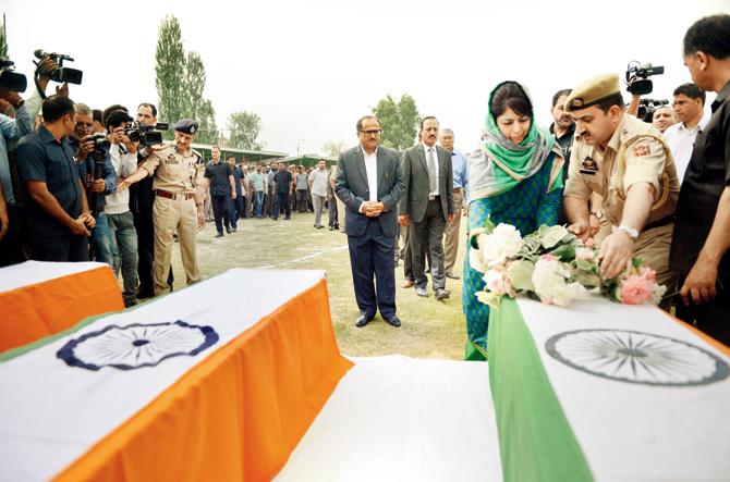Chief Minister Jammu and Kashmir Mehbooba Mufti lays a wreath on the coffin of one of the slain officers. Pics/PTI