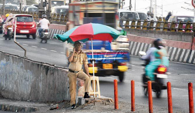 Armed with nothing but a lathi, the constables, like this one posted at the Goregaon flyover, are expected to stop crooks from speeding away on their bikes. Pics/Nimesh Dave