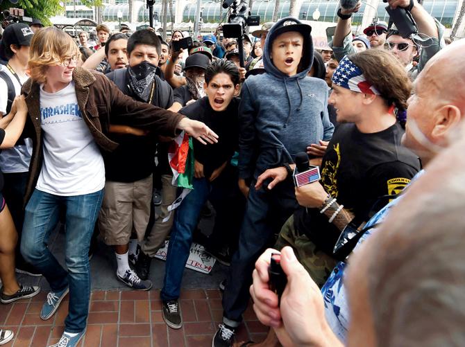 Anti-Donald Trump protesters are threatened with pepper spray by a Trump supporter outside Republican presidential candidate Donald Trump’s election rally event in San Diego, California, on May 27, 2016. Thousands of pro- and anti-Donald Trump demonstrators faced off outside a rally for the presumptive Republican presidential nominee in San Diego. Pic/ AFP
