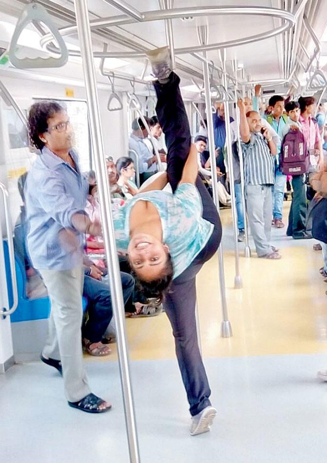 Hanumanasana or monkey pose on the pole.  Benefits: Increases flexibility, alignment and balance.  Location: On the metro to DN Nagar station, Andheri.  PICS/ Meghna Bhalla