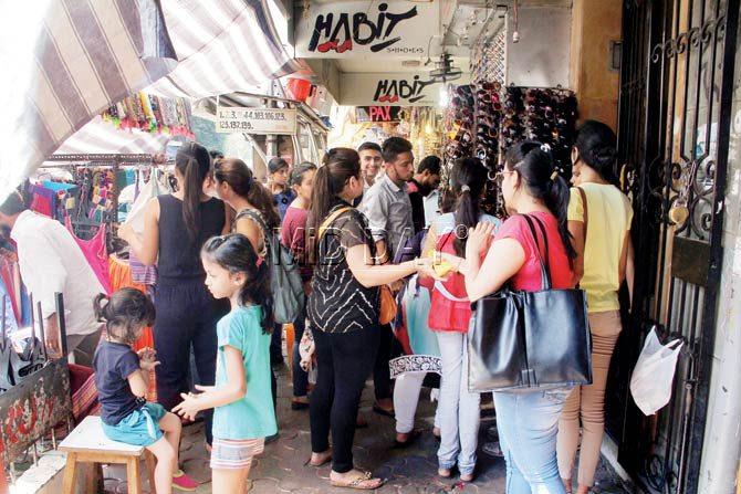 Illegal hawkers block shop fronts by setting up their wares in front of them