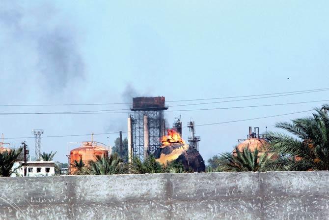 Flames and smoke rise from tanks after a suicide bomb attack on the Taji gas plant in Iraq