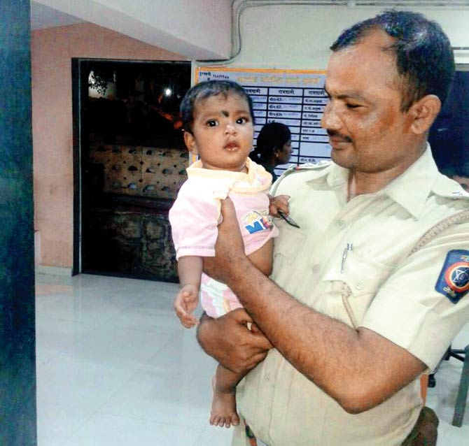 Police Sub-Inspector Manohar Sonawane with the one-year-old girl