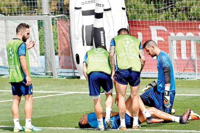Real Madrid striker Cristiano Ronaldo lies on the ground after being injured during a training session in Madrid yesterday. pic/AFP 
