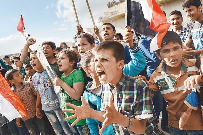 Syrian’s react to the arrival of a Russian military convoy. Pic/AFP