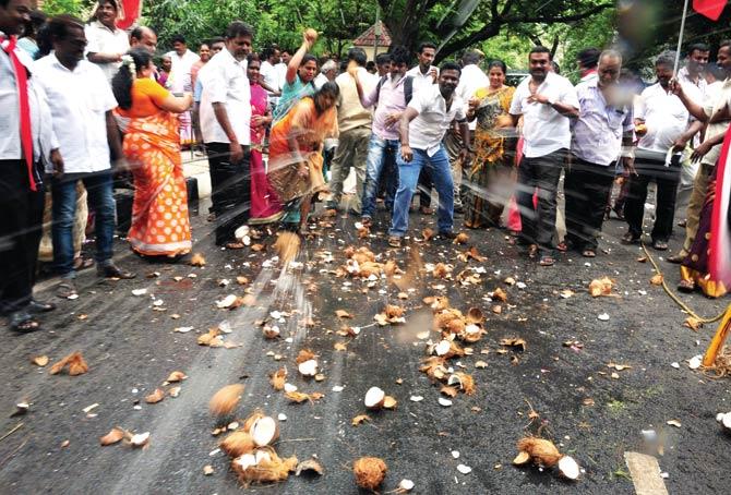 Members of the AIADMK break coconuts as they celebrate victory outside the party office in Chennai yesterday. Pics/PTI