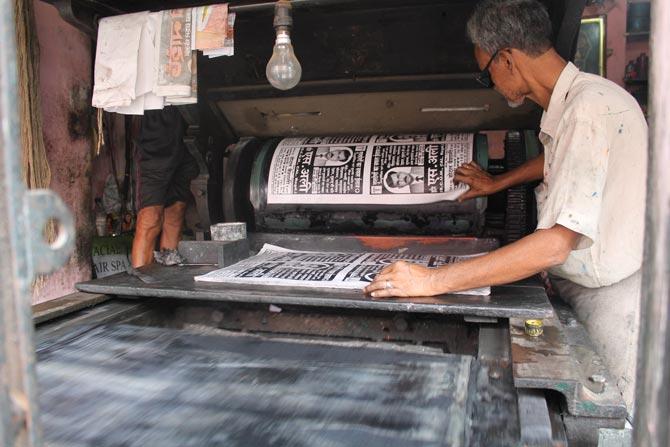 A printmaker prints a typical poster at a Lithography press in Chitpur
