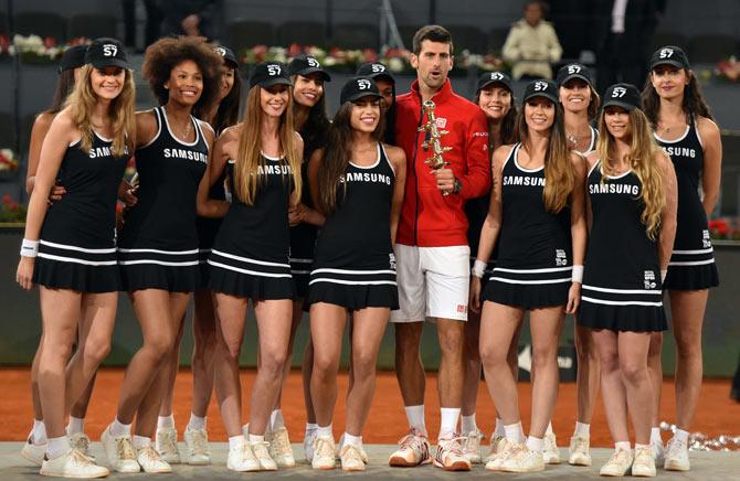 Novak Djokovic poses with ball girls after beating Britain